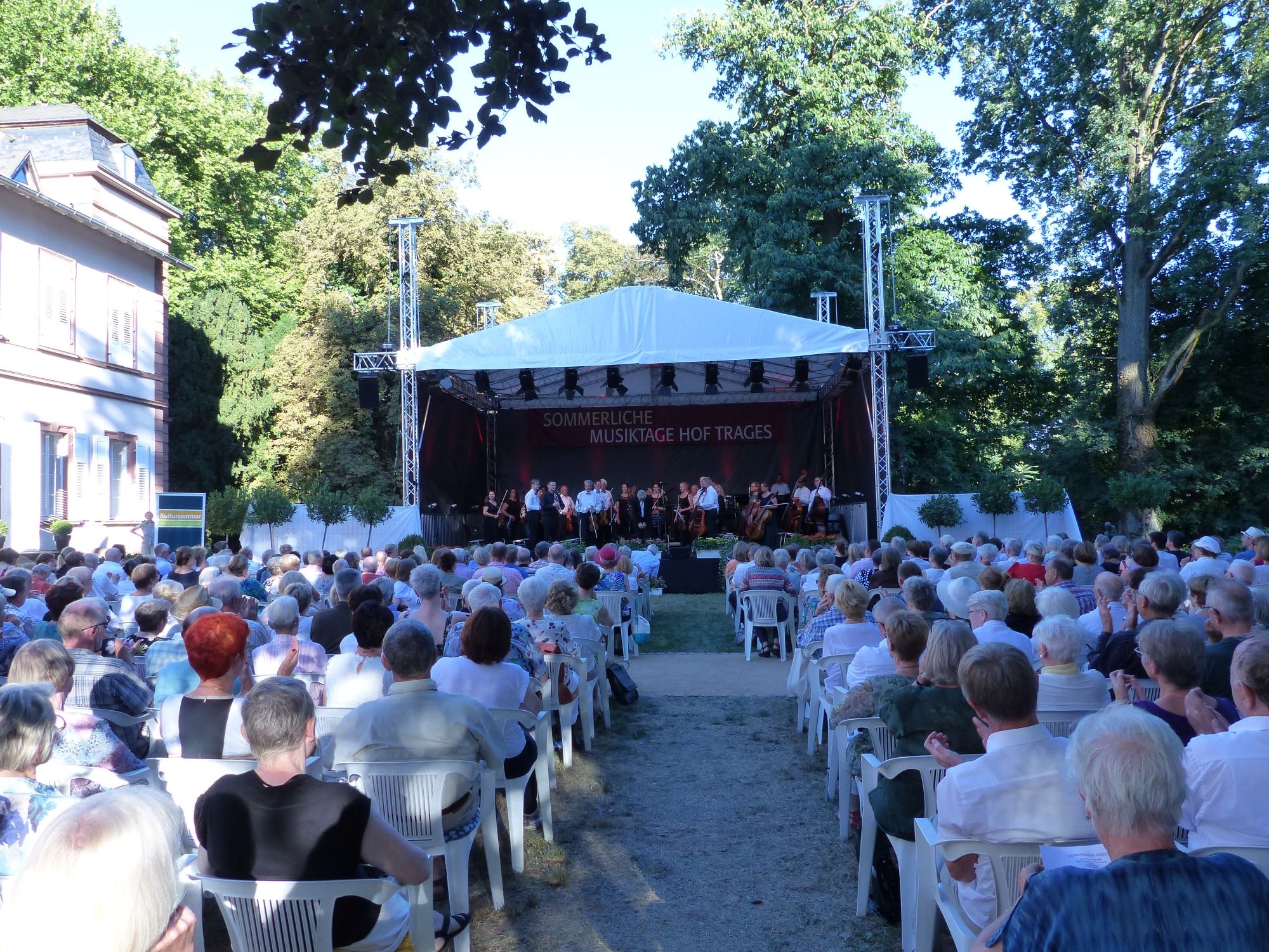 Sommerliche Musiktage Das Foto zeigt die Sommerlichen Musiktage auf Hof Trages mit Besuchern vor der Bühne