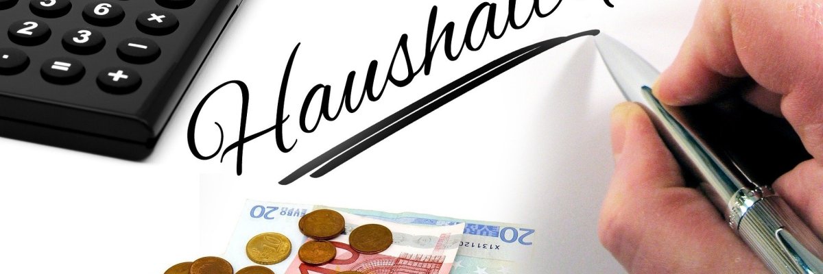 Haushaltsplanung Taschenrechner Geldmünzen Geldscheine und eine schreibende Hand