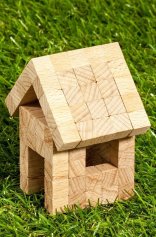 Kleines Klötzchenhaus im Gras stehend