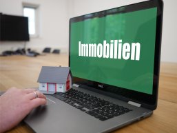 Foto eines Laptopbildschirms, auf dem das Wort "Immobilien" zu lesen ist