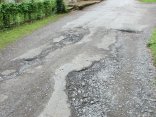 Defekte Straße Das Foto zeigt eine beschädigte Straße