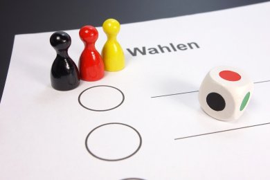 Foto eines Wahlstimmzettels, auf dem drei Mensch ärgere dich nicht Figuren stehen.