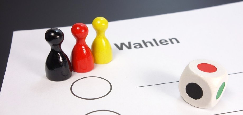 Foto eines Wahlstimmzettels, auf dem drei Mensch ärgere dich nicht Figuren stehen.