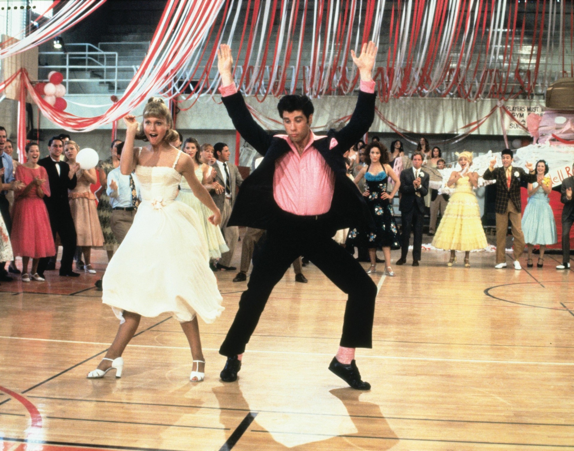 Danny und Sandy legen beim Highschool-Tanzwettbewerb eine flotte Sohle aufs´ Parkett und werden auch unsere Kinobesucher zum Tanz bringen Danny und Sandy tanzen vor ihren Mitschülern auf einem Highschool Tanzwettbewerb