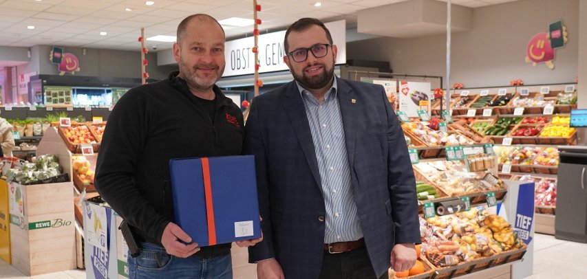 Bürgermeister Waldemar Gogel gratuliert Rewe-Chef Jürgen Herröder zur Wiedereröffnung seines Marktes.