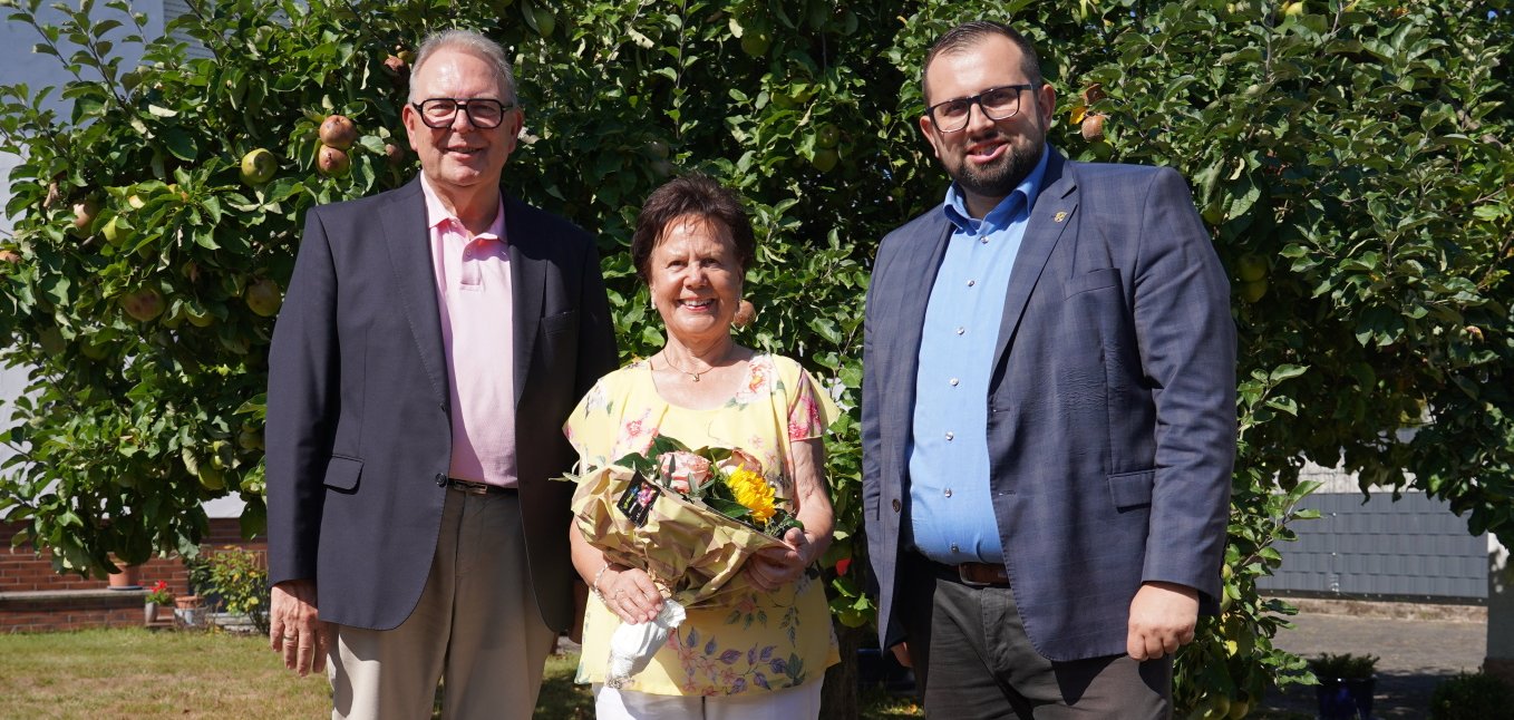 Die Jubilarin Renate Tautges freut sich über die Glückwünsche der Gemeinde, die Bürgermeister Waldemar Gogel und Erster Beigeordneter Heinz Höfler gemeinsam mit einem Blumenstrauß überbrachten.